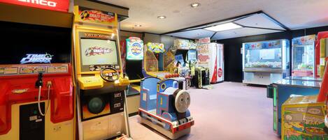 An arcade with various gaming machines, including a Thomas the Tank Engine-themed game.