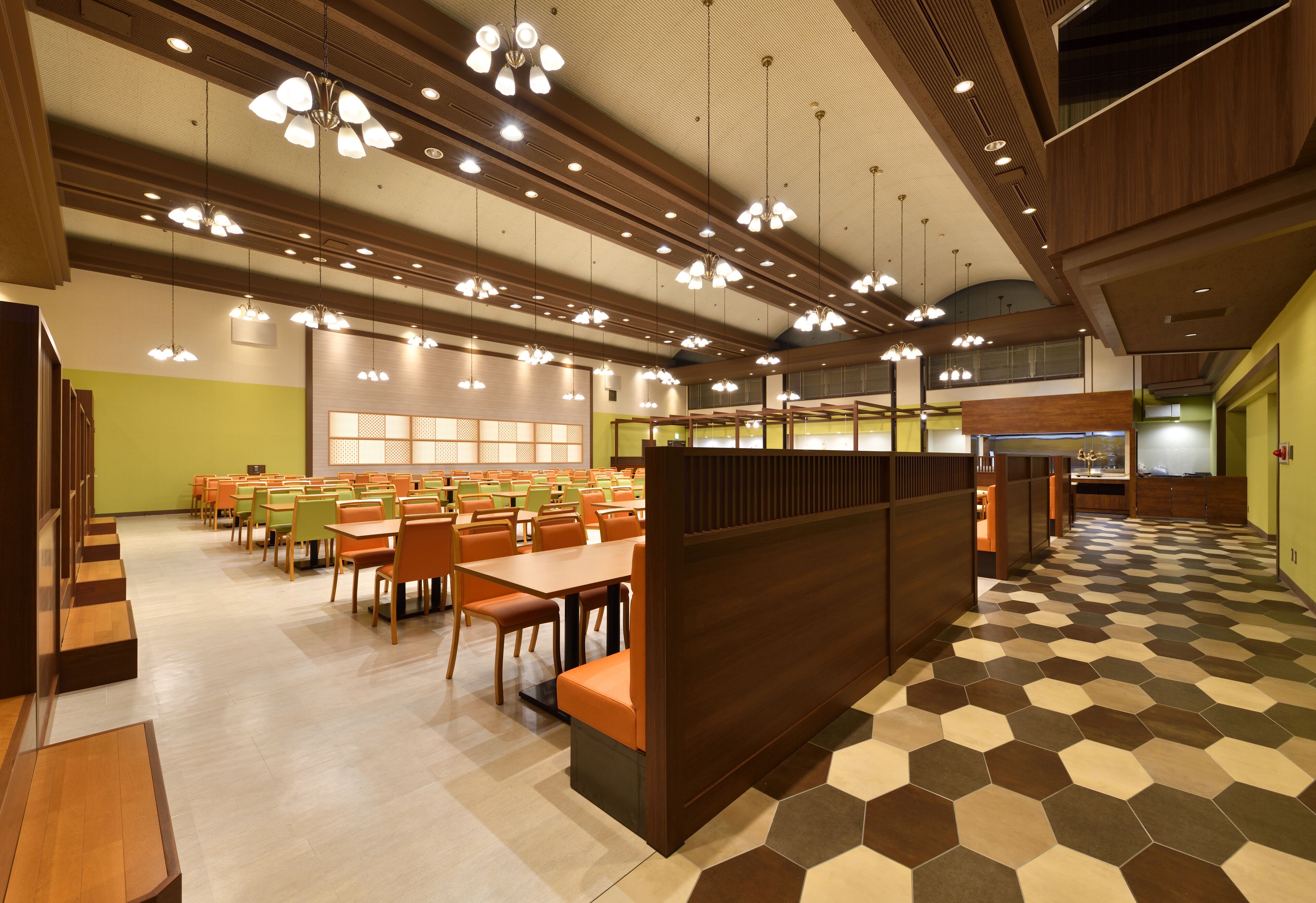 A spacious dining area with multiple tables and chairs, a central seating area, and a patterned floor.