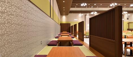 Une rangée de tables en bois surmontées de coussins violets, un mur à motifs et une cloison en bois dans un intérieur moderne.