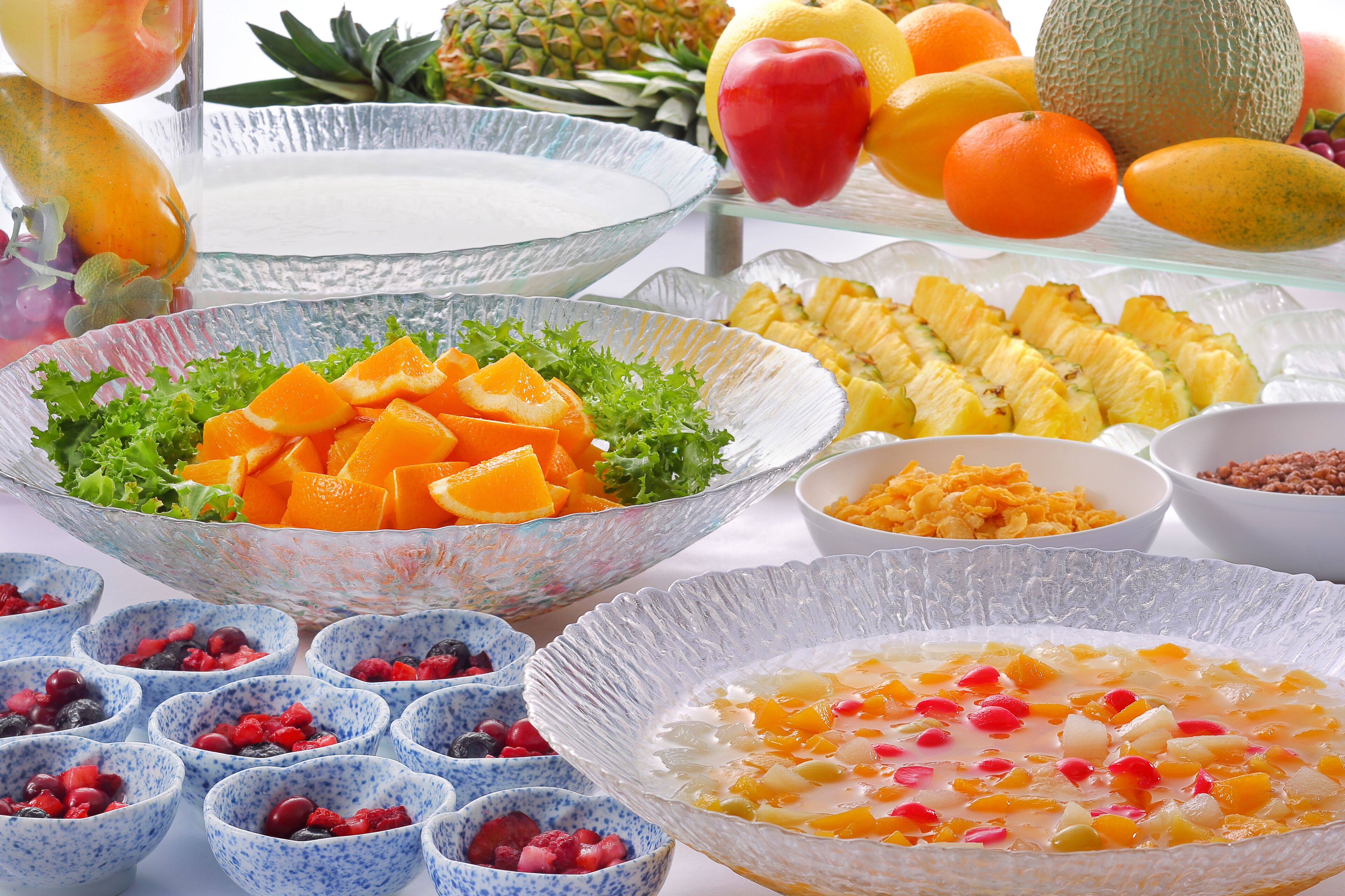 A variety of fruits and bowls of food on a table.