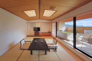 Une pièce de style japonais traditionnel, avec un sol recouvert de tatamis, une table basse et des chaises.