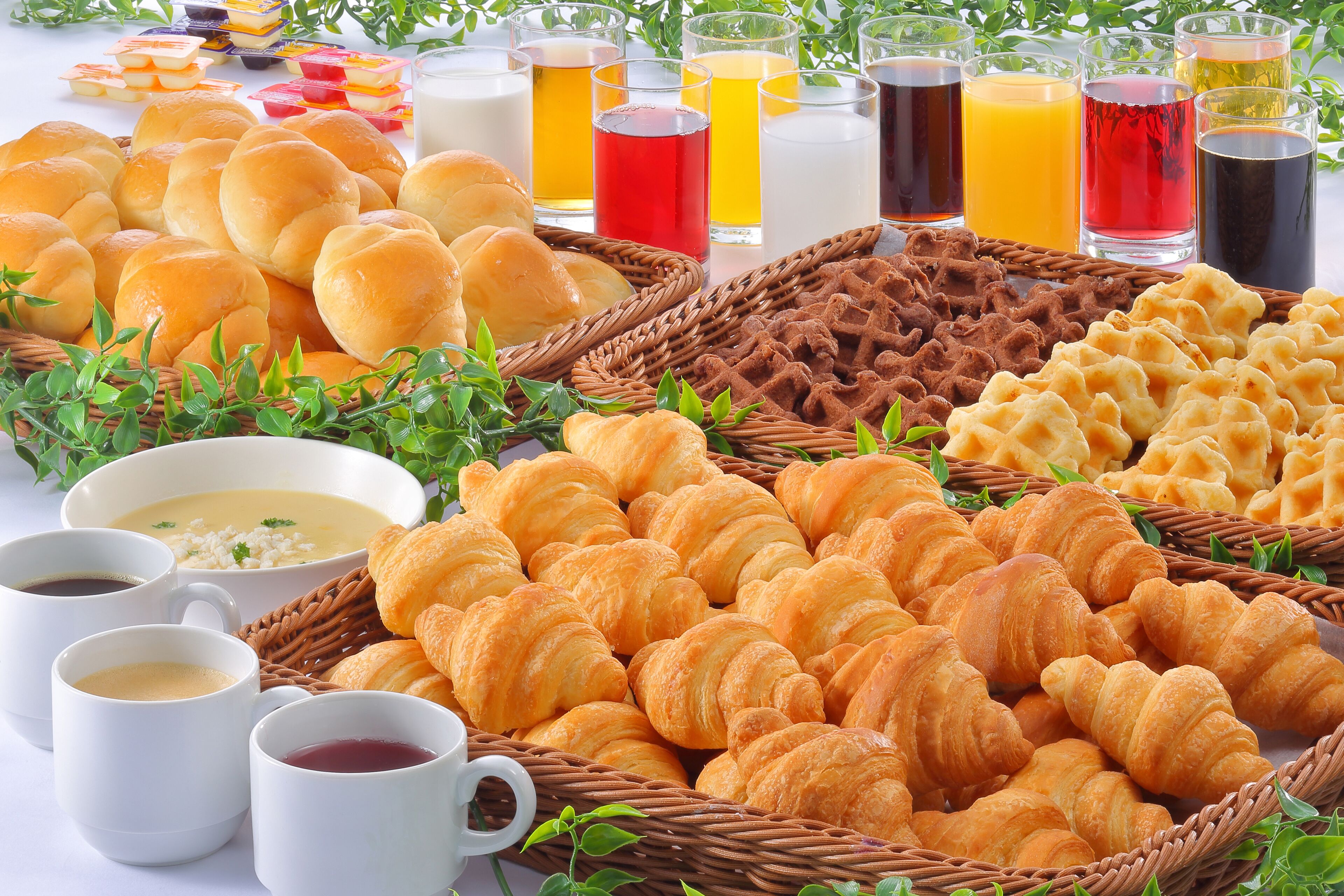 Un bufé de desayuno con diversos pasteles, panes y bebidas.