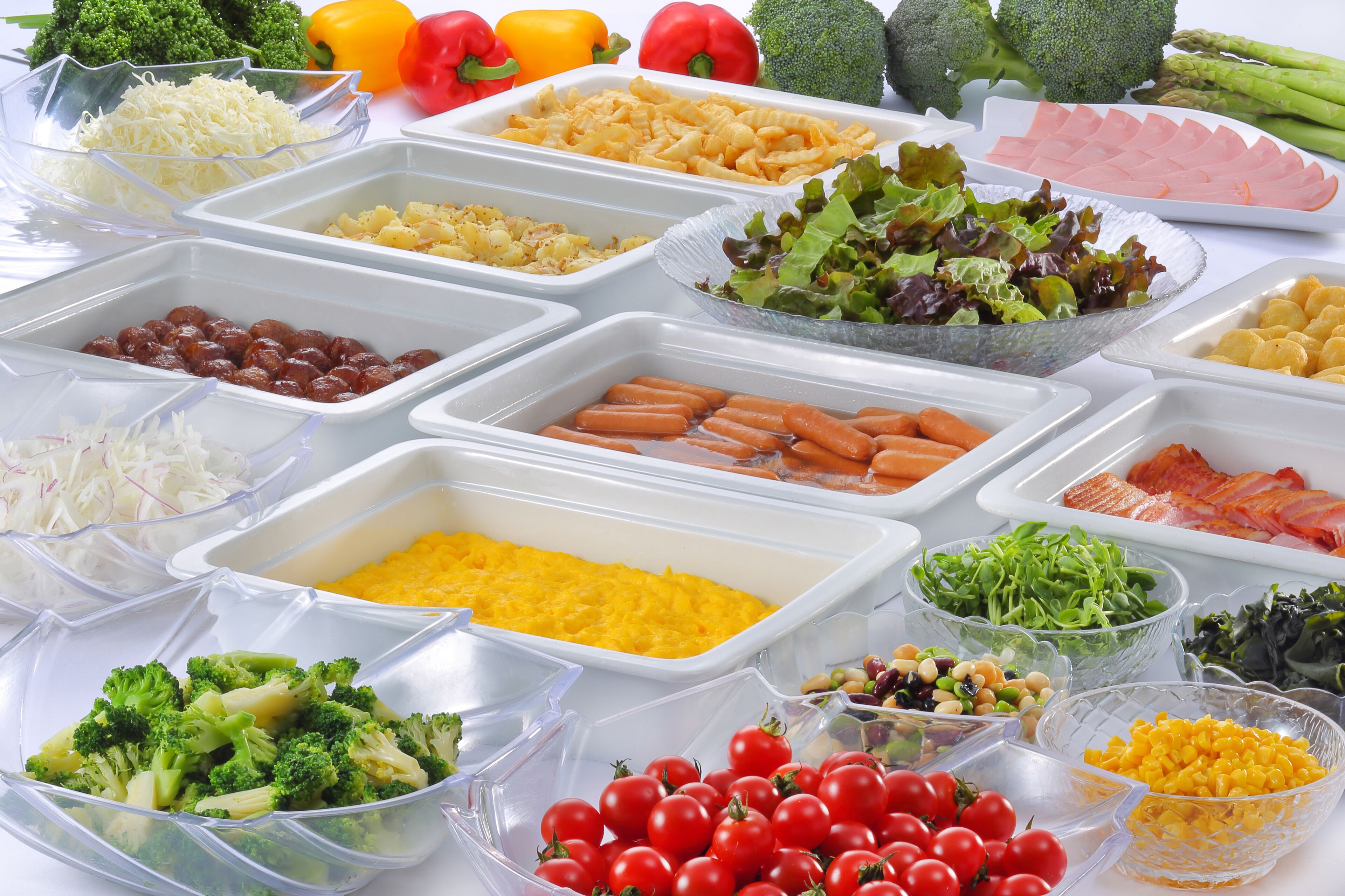 Diversos alimentos en recipientes transparentes, como brócoli, tomates y pasta.
