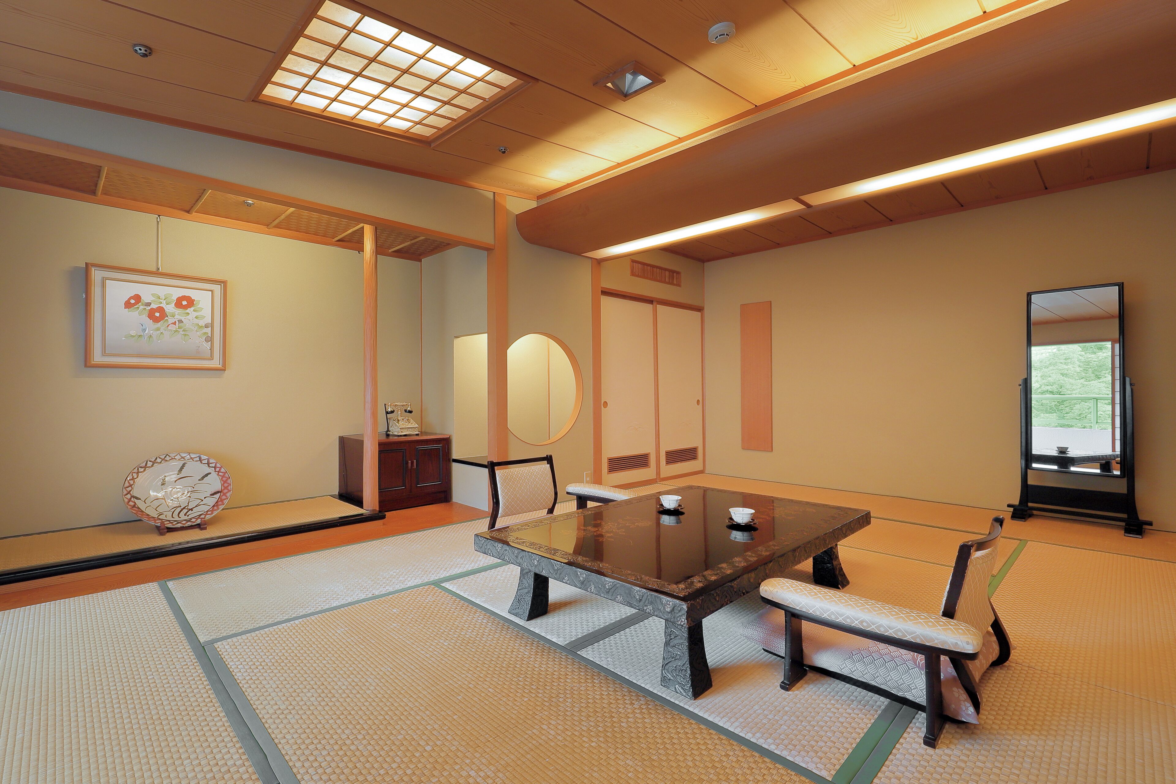 A traditional Japanese room with tatami flooring, a low table, and a bench.