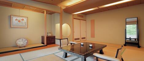A traditional Japanese room with tatami flooring, a low table, and a bench.