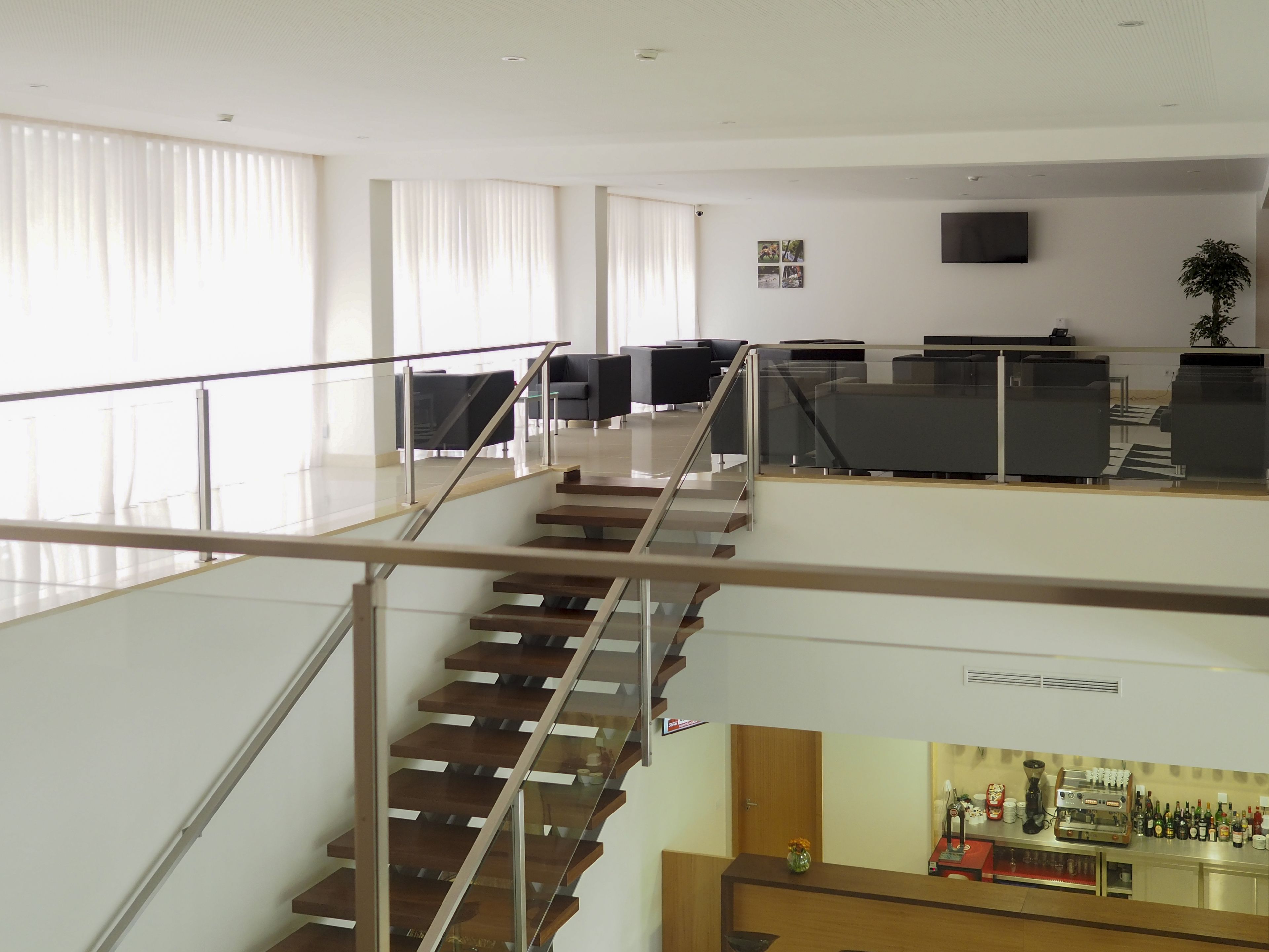 Een modern interieur met een trap, zithoek en een bar.