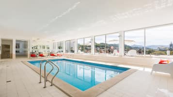 Een binnenzwembad en ligstoelen