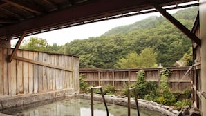 A traditional wooden bathhouse with a stone floor and a wooden fence. - Kinugawa Niouson Plaza (Nikko)