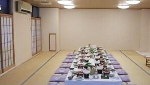 A traditional Japanese room with tatami flooring, a low table with cushions, and a sliding door. - Kinugawa Niouson Plaza (Nikko)