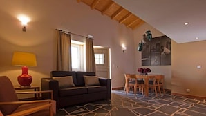 A living room with a sofa, chairs, a dining table, and a red lamp. - Herdade da Urgueira (Vila Velha de Rodao)