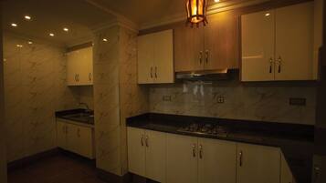 A modern kitchen with marble walls, white cabinets, and a central island.