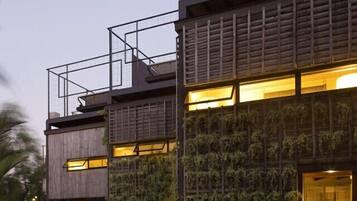 Un bâtiment moderne doté d’une façade en bois, de grandes fenêtres et d’un balcon.