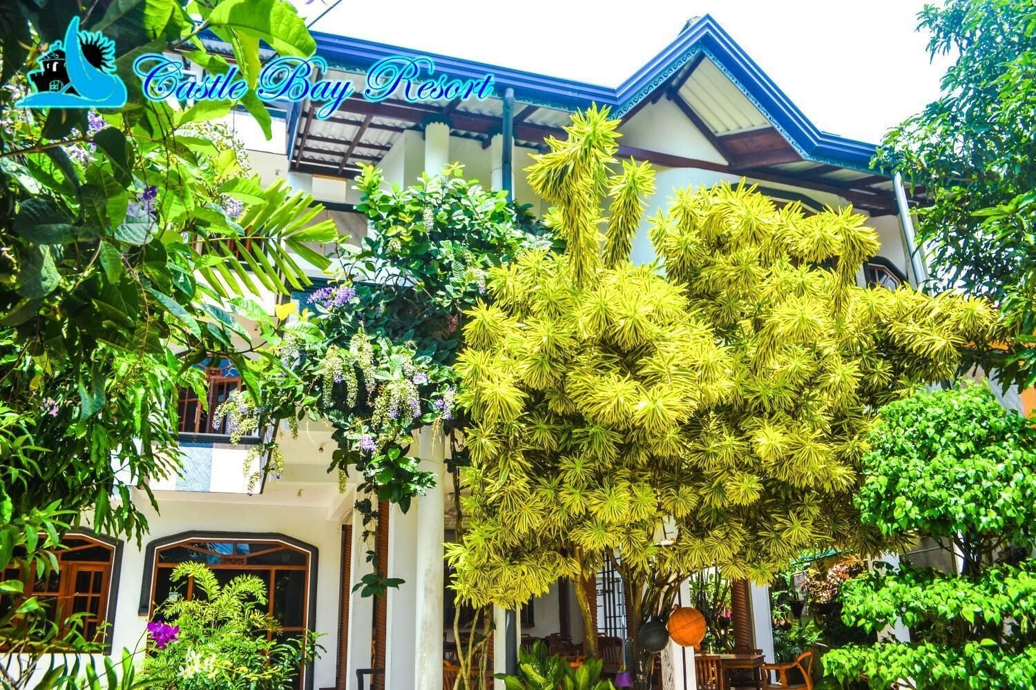 A traditional building with a sign reading "Castle Bay Resort".