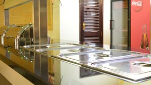 A buffet area with stainless steel serving trays and a Coca-Cola refrigerator. - Eagle Palace Hotel (Nakuru)