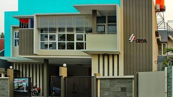 A modern two-story building with a prominent 'GRIVA' sign, featuring a flat roof, large windows, and a gated entrance.