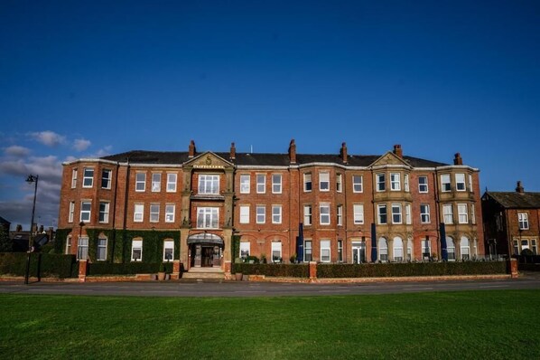 A large, multi-story brick building with a central entrance and symmetrical windows. - Clifton Arms Hotel (Lytham St. Anne's)