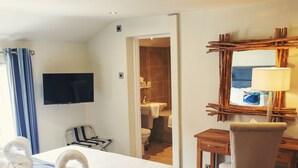 A hotel room with a bed, a desk, a chair, a television, and a bathroom visible through an open door. - Clifton Arms Hotel (Lytham St. Anne's)