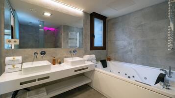 A modern bathroom with two sinks, a bathtub, a large mirror, and a window.