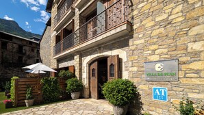 A stone building with a sign for 'VILLA DE PLAN APARTAMENTOS PASSION FOR NATURE.' - Apartamentos Villa de Plan (Plan)