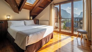 A bedroom with a bed, a nightstand, a lamp, and a view of a balcony with a railing. - Apartamentos Villa de Plan (Plan)
