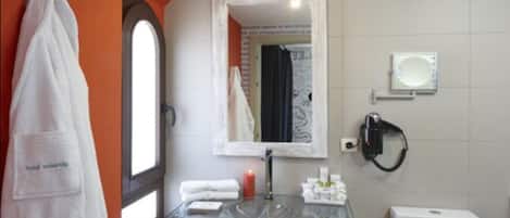 Un baño con lavamanos de cristal, inodoro y toallero.