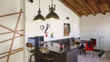 Una cocina moderna con techo de madera, lámparas colgantes y una isla central con taburetes de bar.