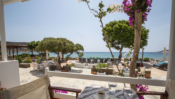A terrace with outdoor seating, a table with drinks, and a view of the sea. - Pension Ageliki (Sifnos)