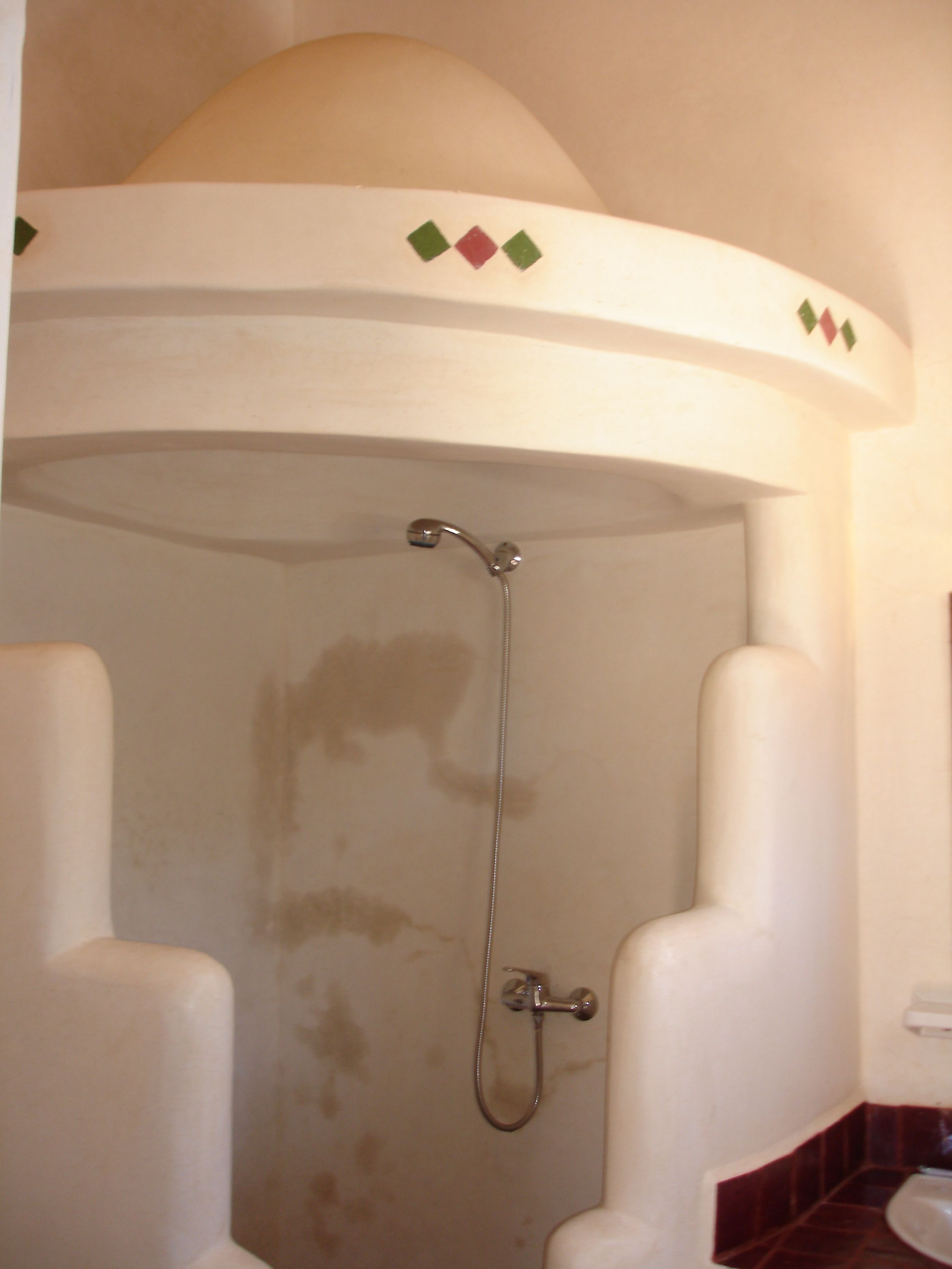 A bathroom with a shower enclosure, a toilet, and a sink.