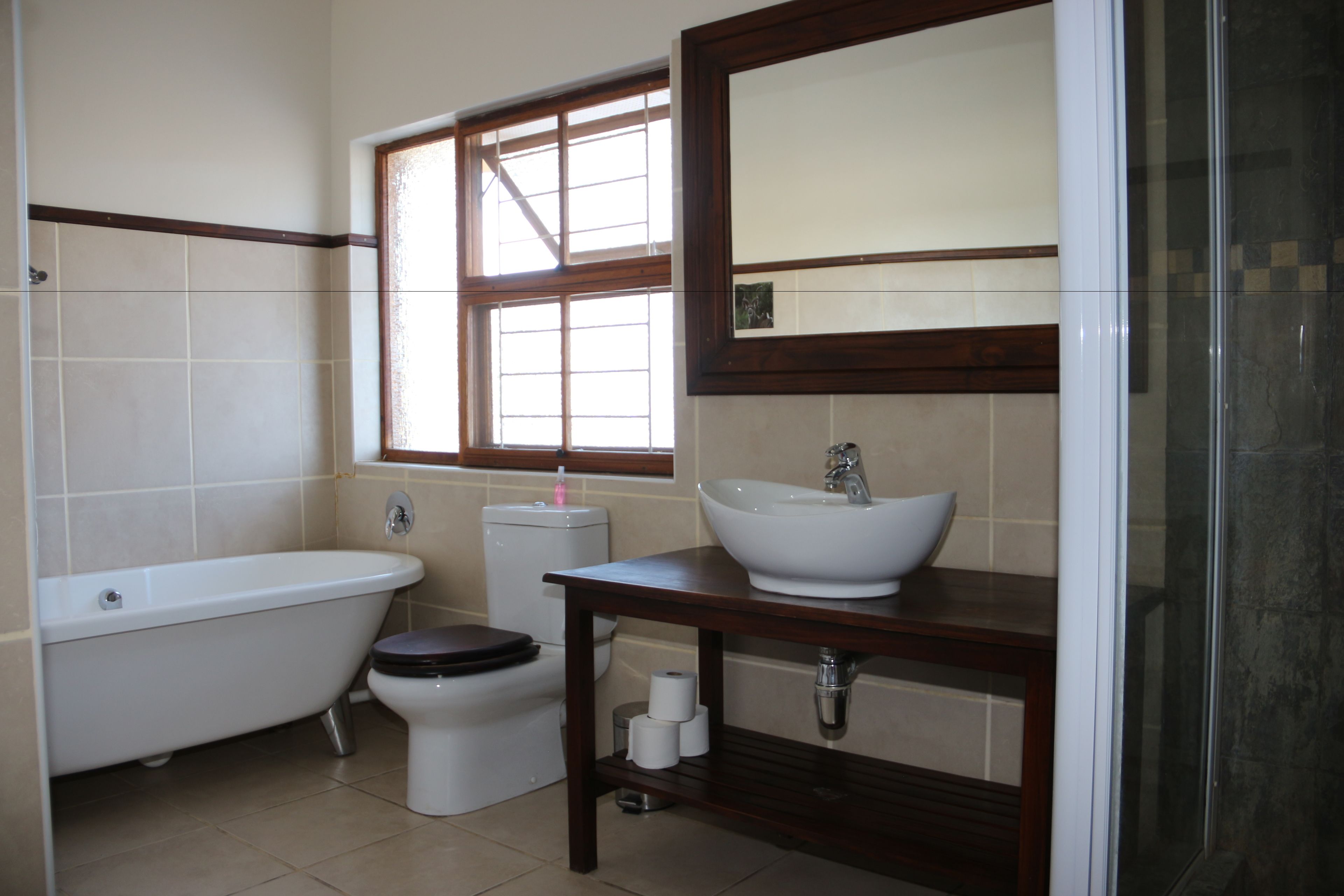 Une salle de bain avec une baignoire, des toilettes, un lavabo et une fenêtre.