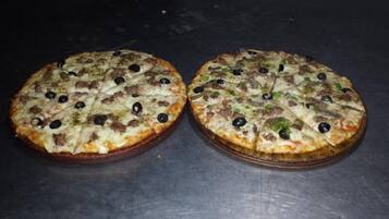 Two pizzas on a table.