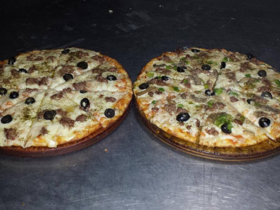 Two pizzas on a table.