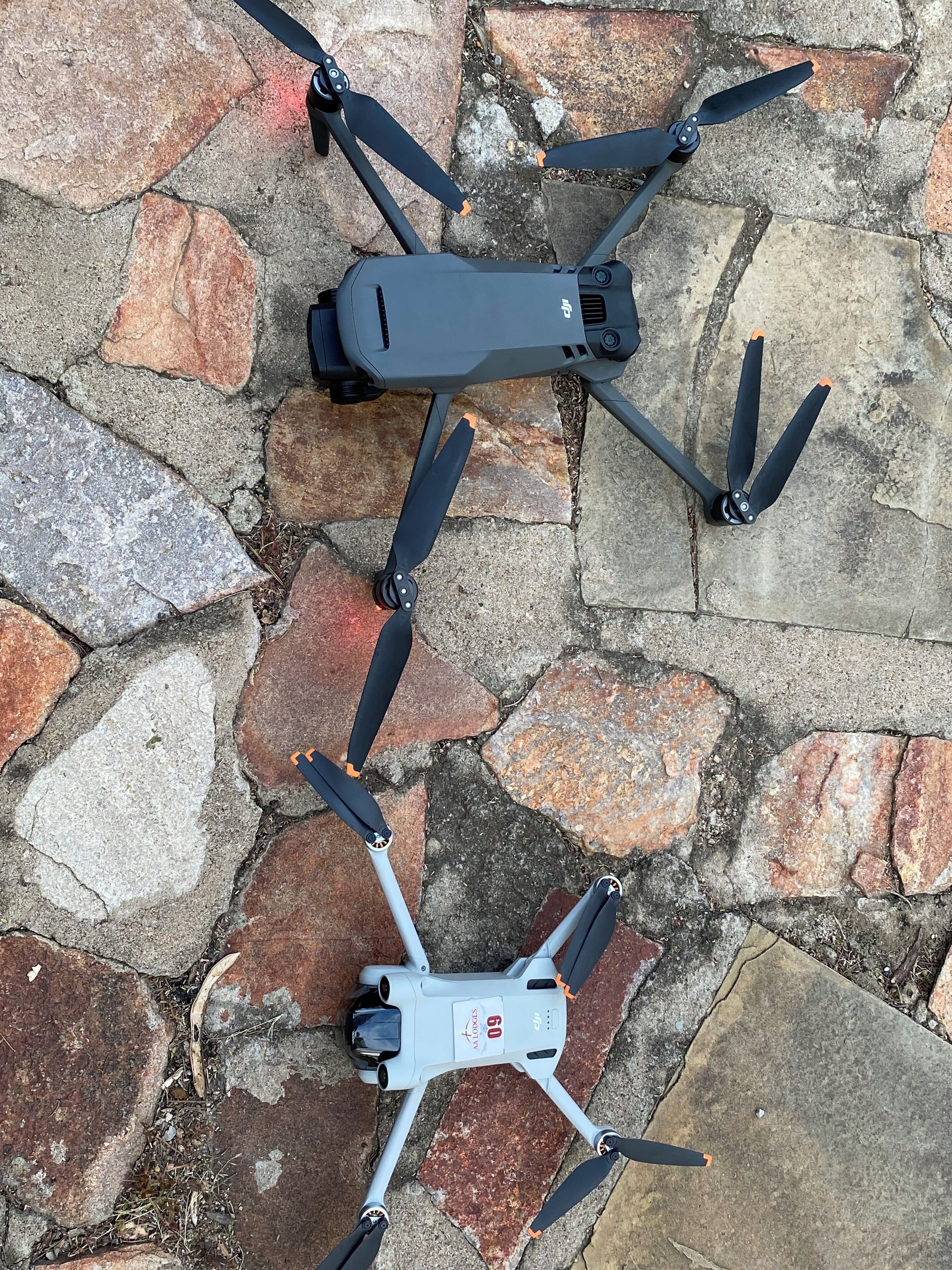 Dos drones sobre una superficie empedrada.