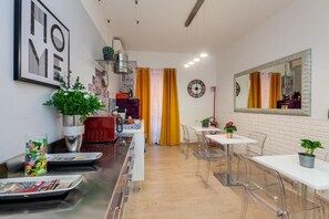 A modern kitchen with a central island, clear chairs, and a dining table. - St. Peter's Relax (Rome)