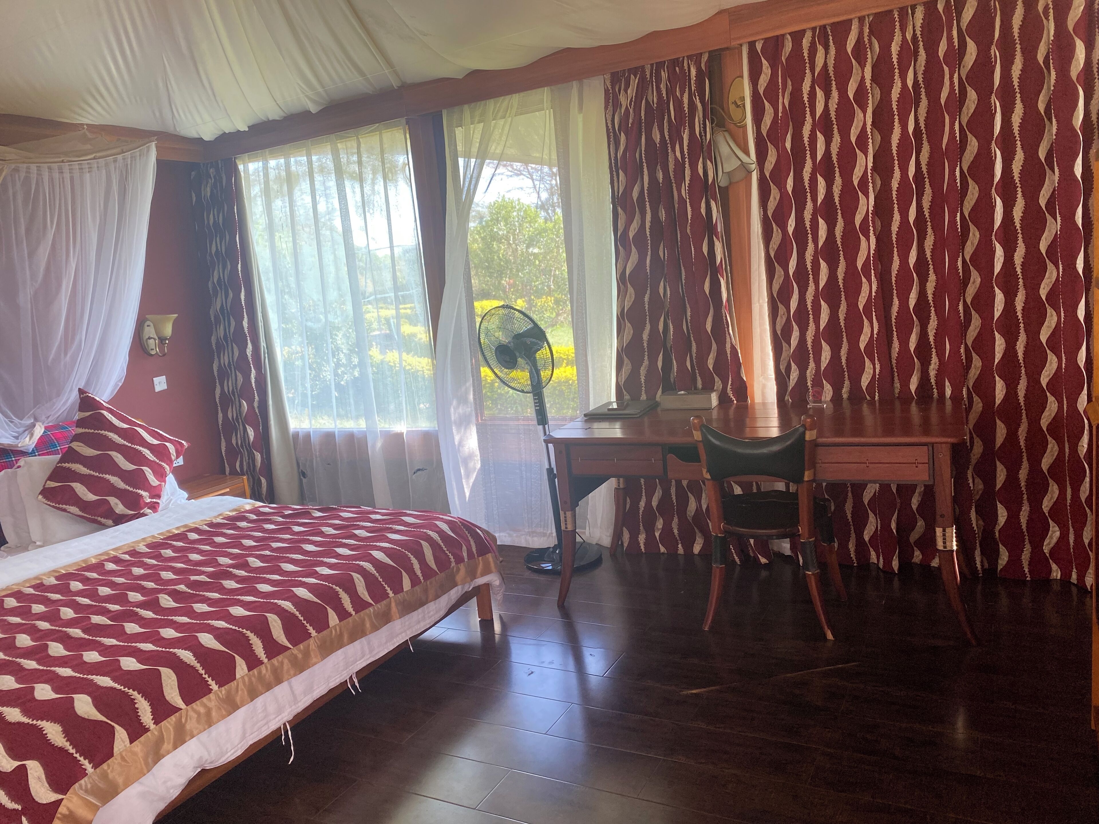 A bedroom with a bed, a desk, and a chair.