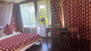 A bedroom with a bed, a desk, and a chair.