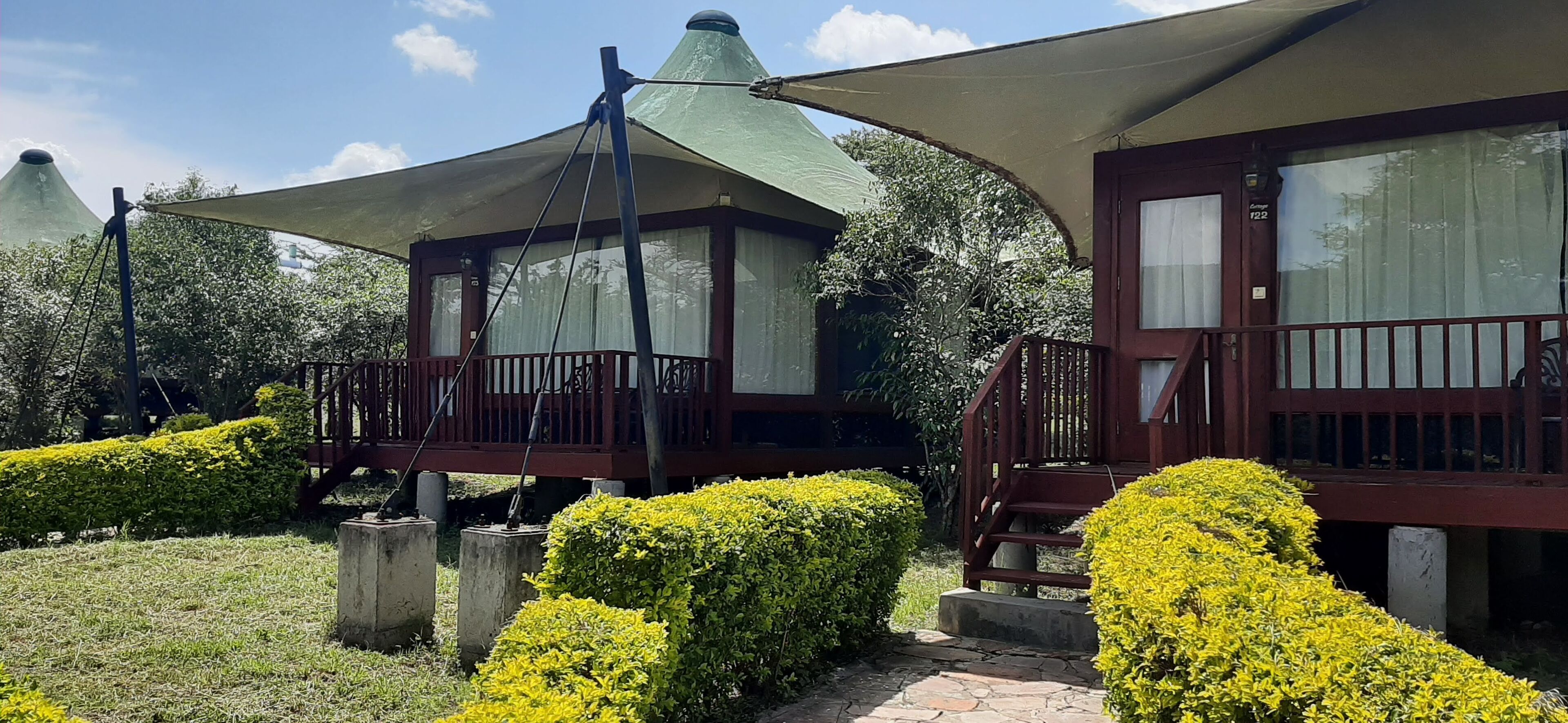 A building with a covered outdoor area, a wooden deck, and a stone pathway.