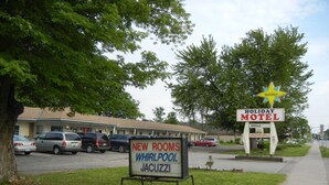 Une enseigne indiquant un motel proposant des offres spéciales pour les vacances, avec une étoile et un panneau publicitaire annonçant de nouvelles chambres dotées de baignoires à remous et de jacuzzis.
