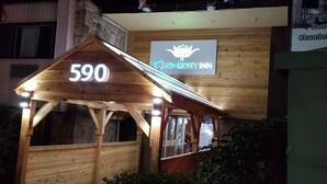 A wooden structure with a neon sign reading "Chomedey Inn" and the number "590" above it.