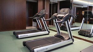 A gym with treadmills and a mirrored wall. - Gloria Plaza Hotel Qingdao (Qingdao)