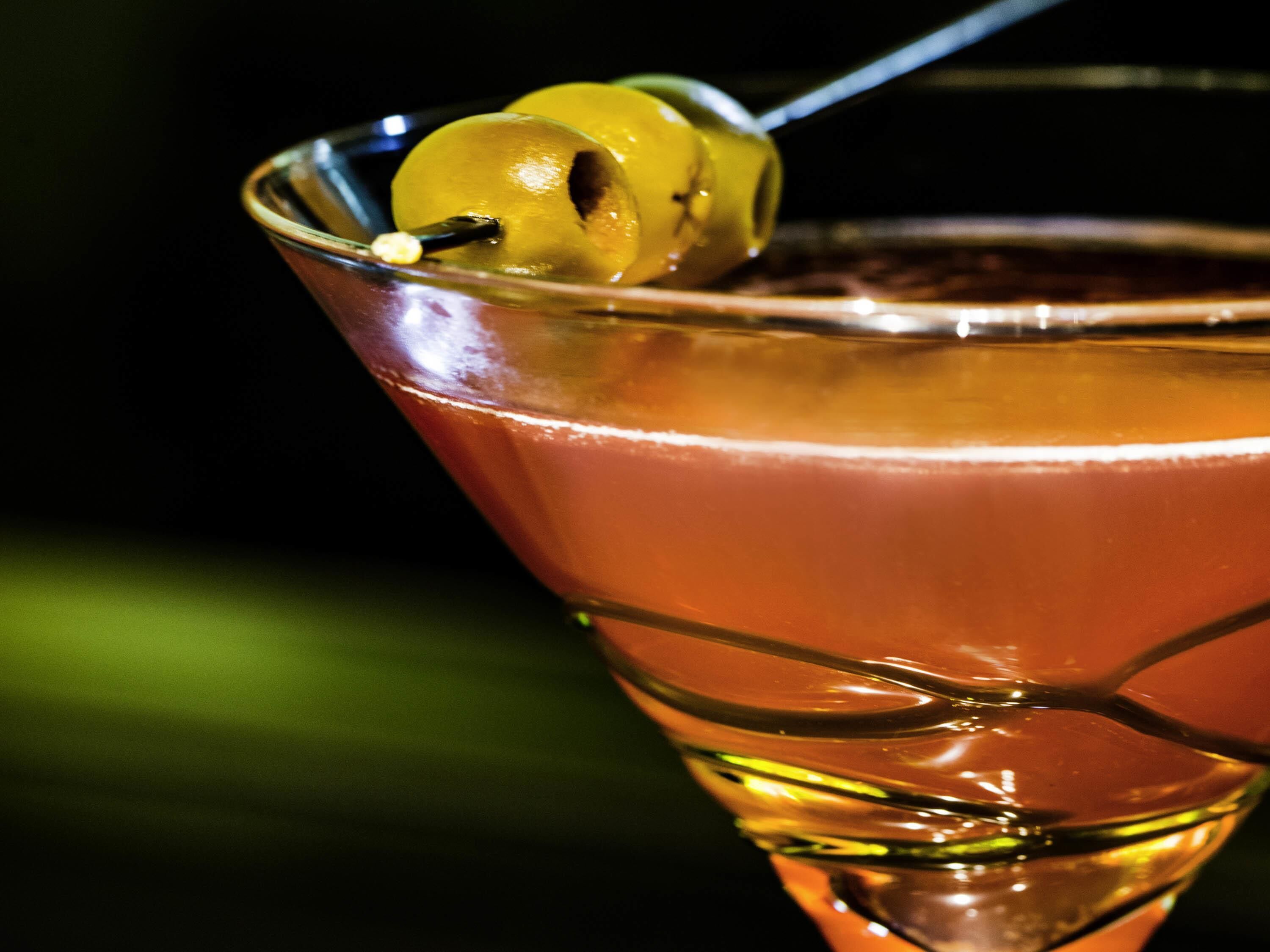 A cocktail in a martini glass with a lemon garnish.