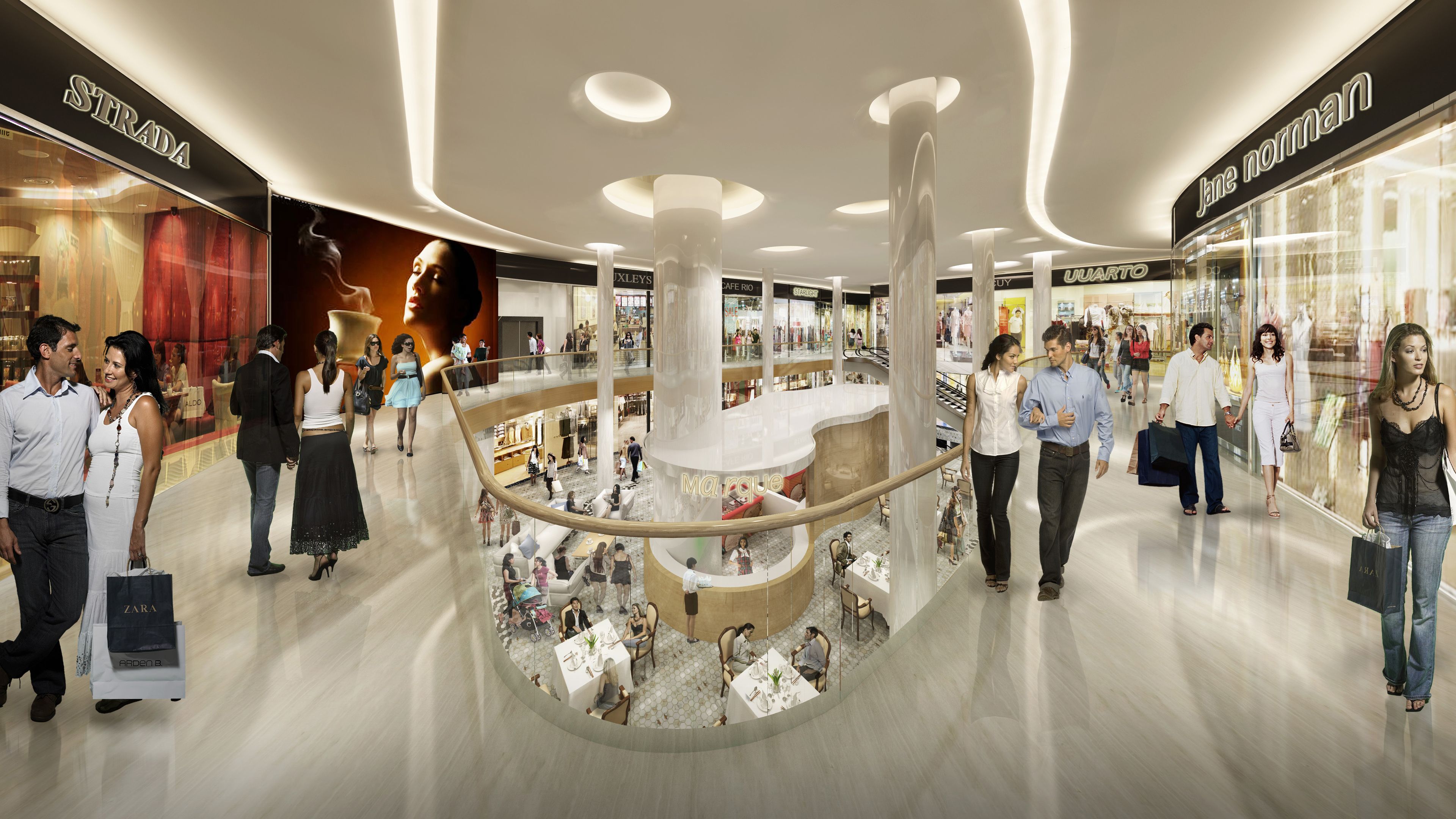 L’intérieur d’un centre commercial moderne, doté de plusieurs niveaux, de rampes en verre et de divers magasins.
