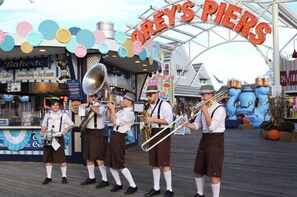 A band performing on a pier with a sign reading 'OREY'S PIER'. - Paradise Inn (Wildwood)
