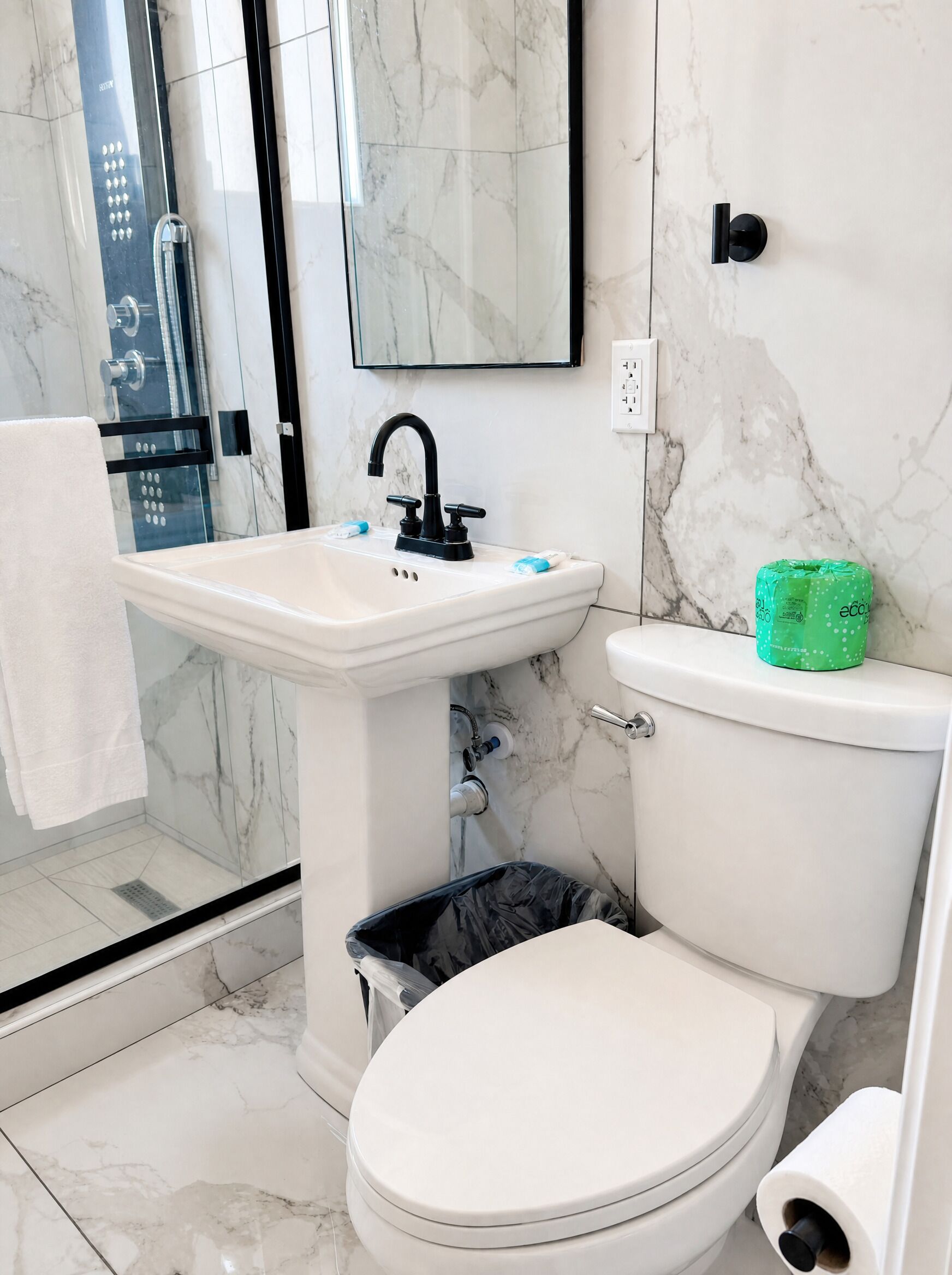 A bathroom with a toilet, sink, and shower.