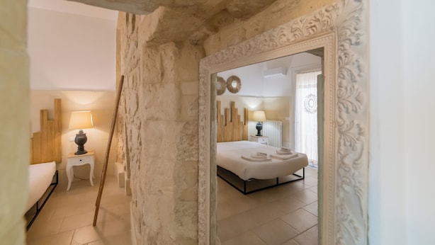 A bedroom with a bed, bedside tables, and a mirror.