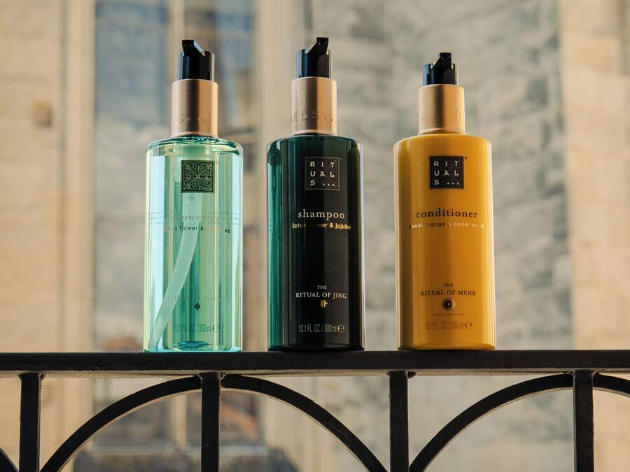 Tres botellas de productos Ritual de JIng sobre una barandilla.