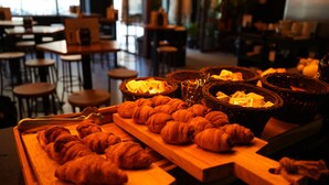 Una vitrina de panadería con croissants y panes en una cafetería.