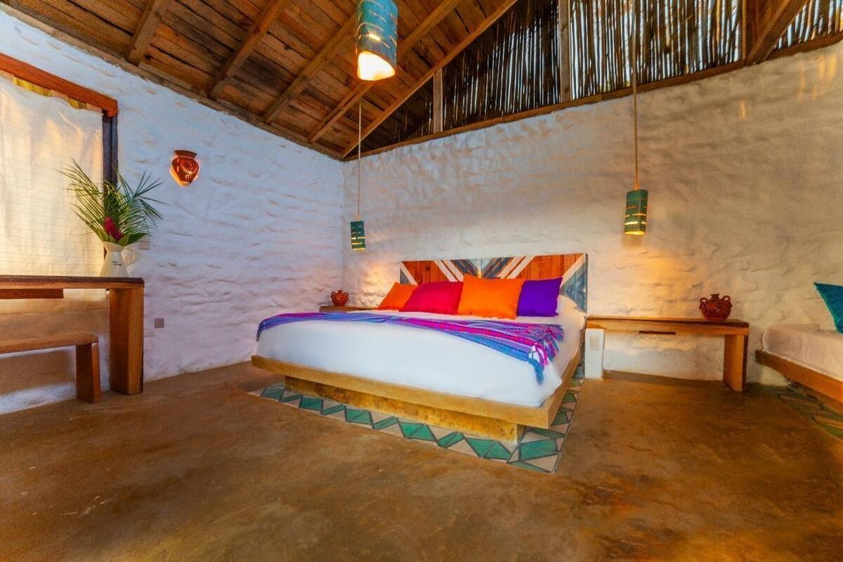 Una habitación con una cama, muebles de madera y una pared con textura.