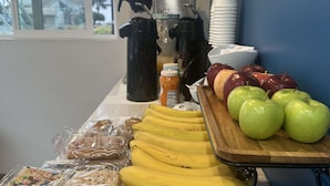 A breakfast buffet with bananas, apples, and packaged snacks. - Super 8 by Wyndham Oceanside Downtown (Oceanside)
