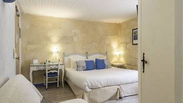 A bedroom with a bed, bedside tables, a desk, and a chair.
