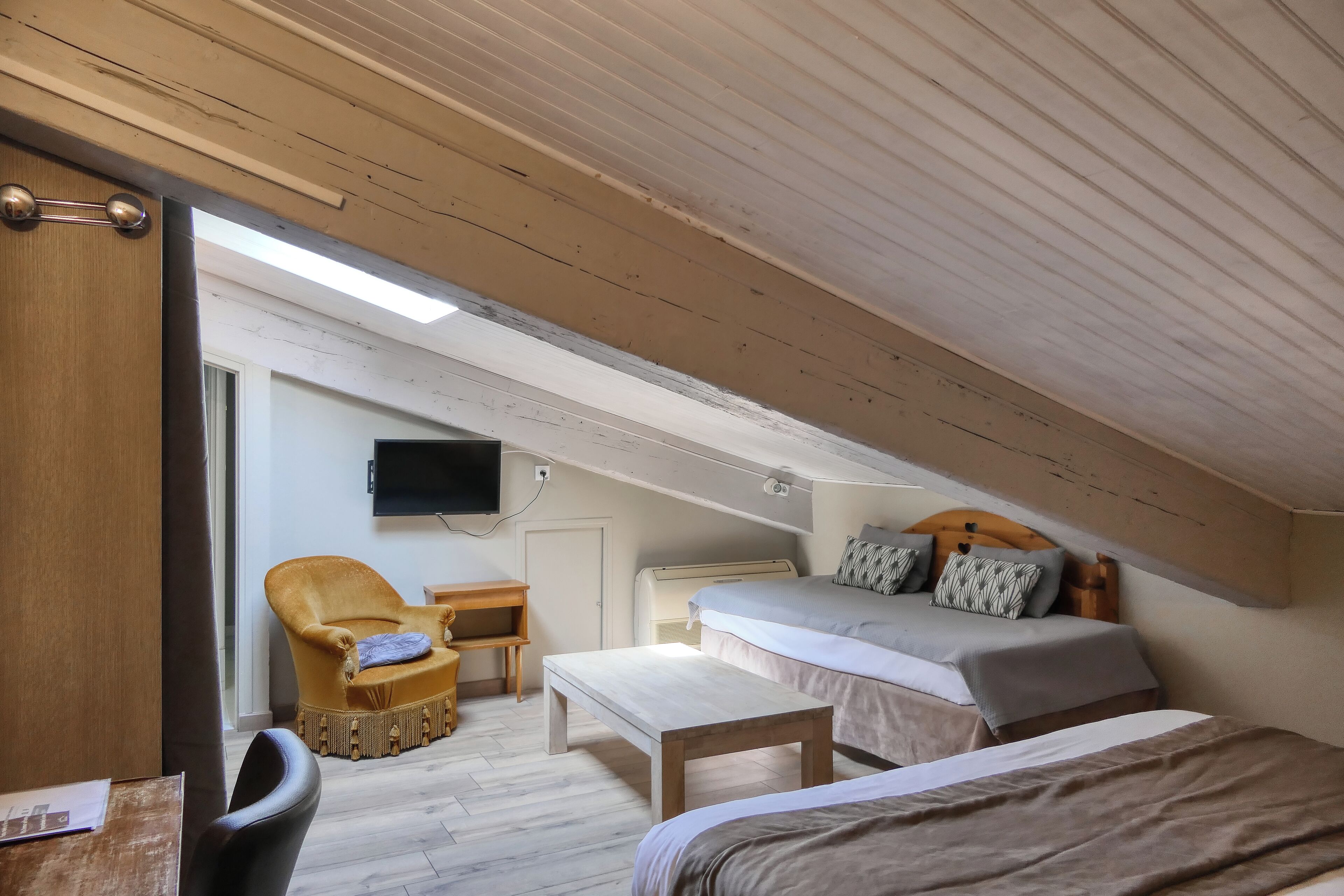 Une pièce comprenant un lit, un bureau, une chaise et un téléviseur.